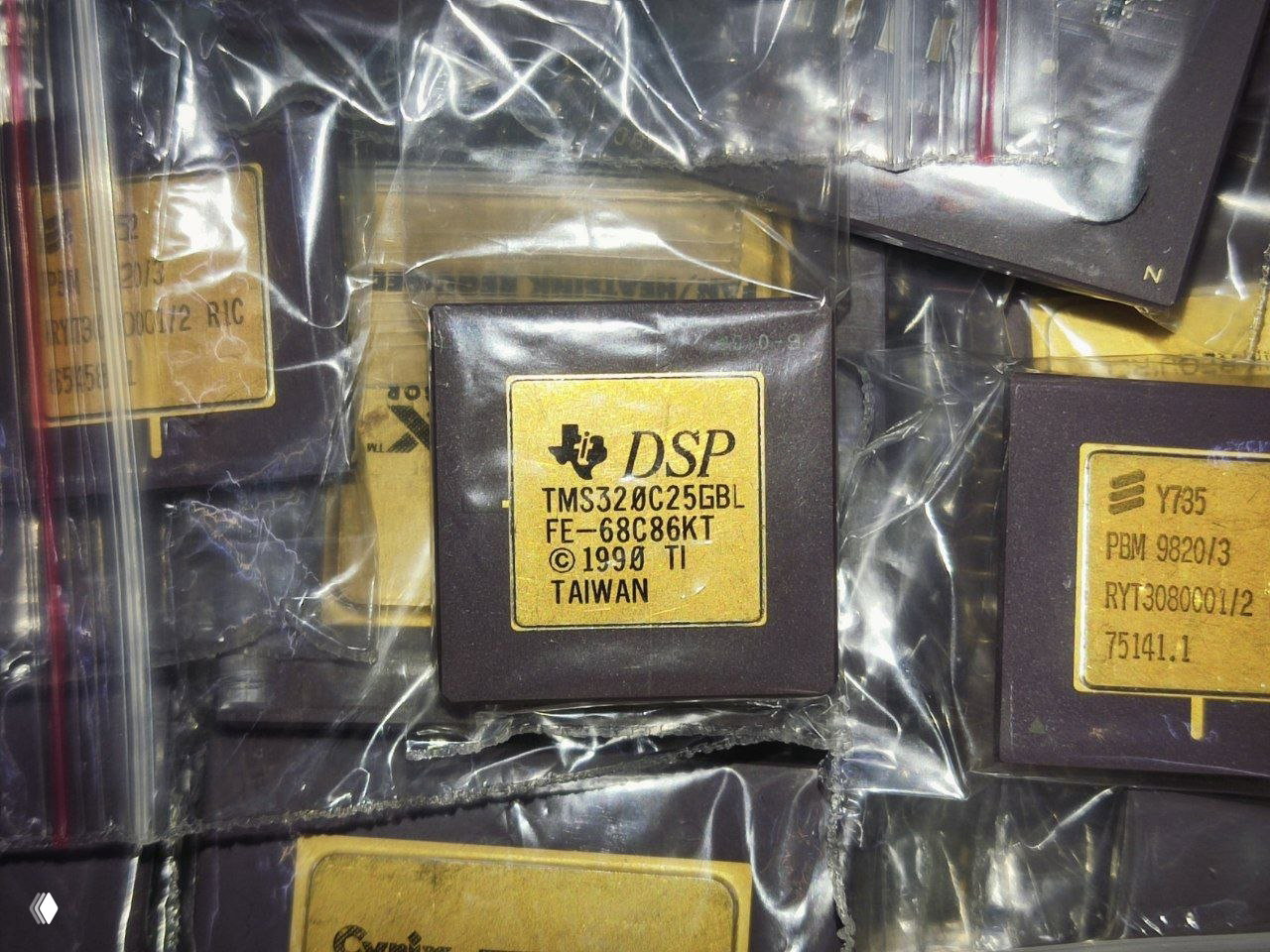 Крупный план DSP‑микросхемы TI с маркировкой TMS320C25 и годом ©1990 на золотой этикетке, находящейся в антистатическом пакете.