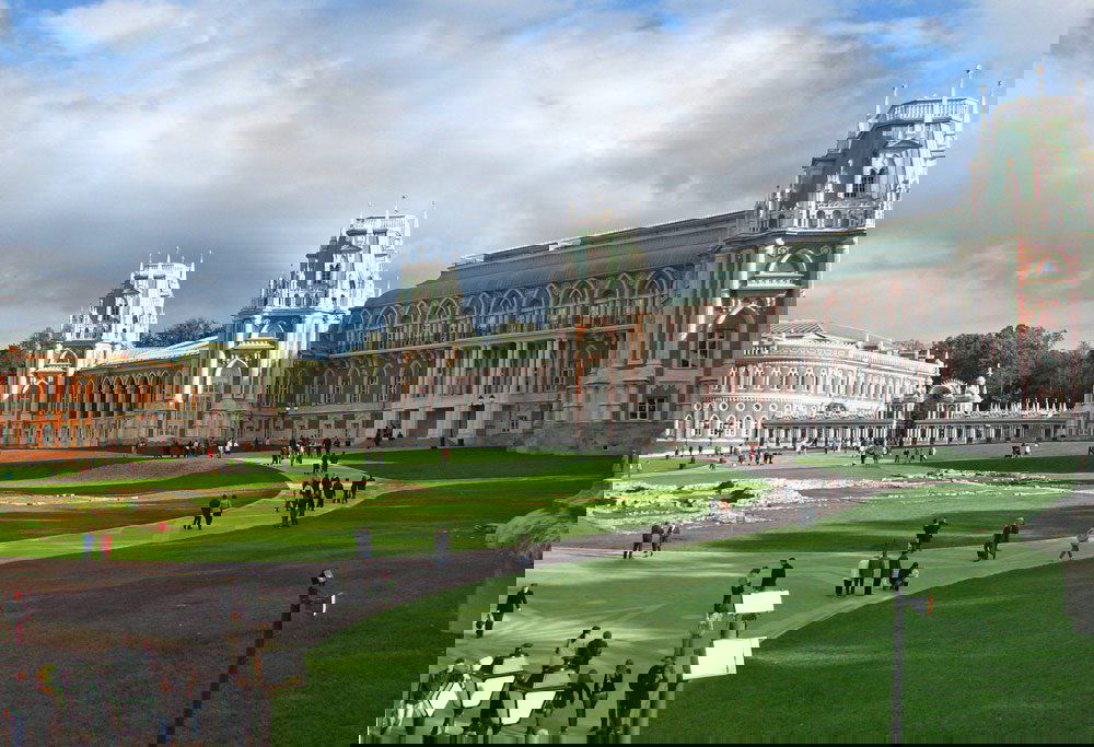 Царицыно: исторический дворцово-парковый ансамбль с зелёными газонами и прогулочными дорожками, посетители на территории усадьбы.