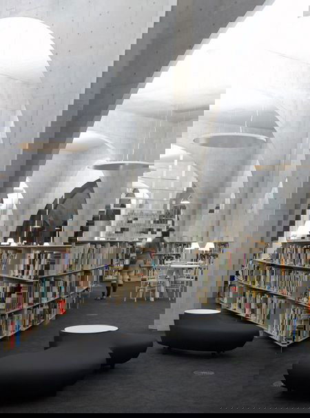 Узкий вид внутренней галереи с арками и компьютерными зонами — сочетание образовательной и выставочной функций первого уровня.