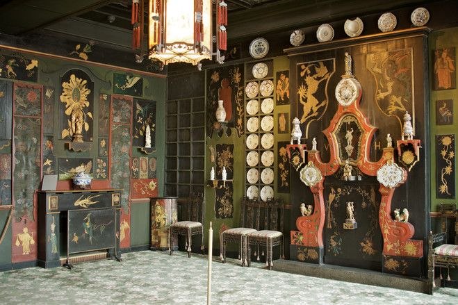 Общий вид зала с чёрно‑зелёными панелями, большим количеством фарфора и украшенным камином — интерьеры дома Виктора Гюго, выраженное увлечение Востоком.