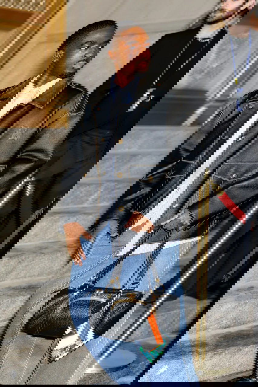 Модель на сцене демонстрирует серьгу в виде миниатюрной книги — серьга-брелок висящая у уха на показе мод.