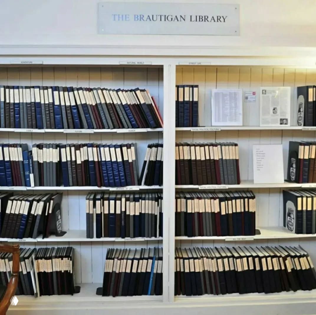 Интерьер библиотеки: белые стеллажи, аккуратно стоящие переплетённые тетради и папки с рукописями, каждая подписана этикеткой и организована по полкам.