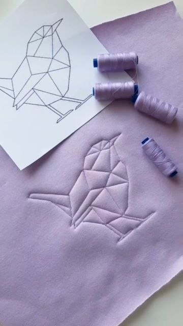 Мотив птицы и швейные нити: бумажный эскиз рядом с объёмной строчной вышивкой на ткани — рабочий кадр мастер‑класса.