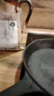 Чугунная сковорода на плите — кадр показывает рабочую поверхность и посуду для приготовления попкорна из амаранта и обжарки семян.