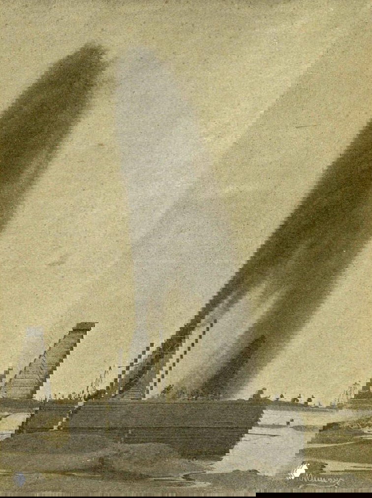 Чёрно‑белая фотография фонтанирующей нефтяной скважины с вышками и рабочим пейзажем — типичный кадр нефтяной добычи того периода.