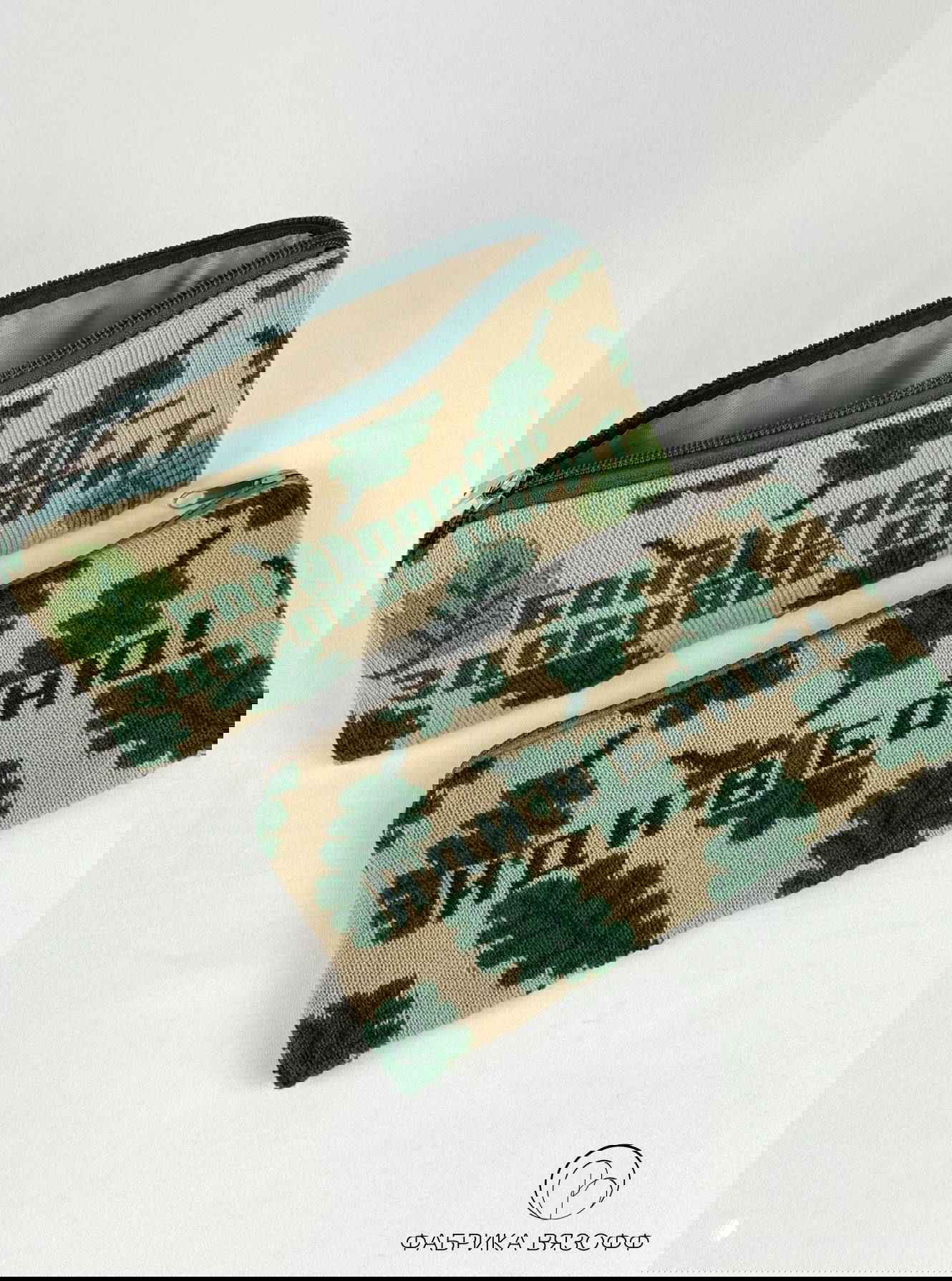 Две вязаные косметички на белом фоне, крупный зелёный орнамент листьев и текстовый мотив на лицевой стороне; логотип «ФАБРИКА ВЯЗОФФ» в углу