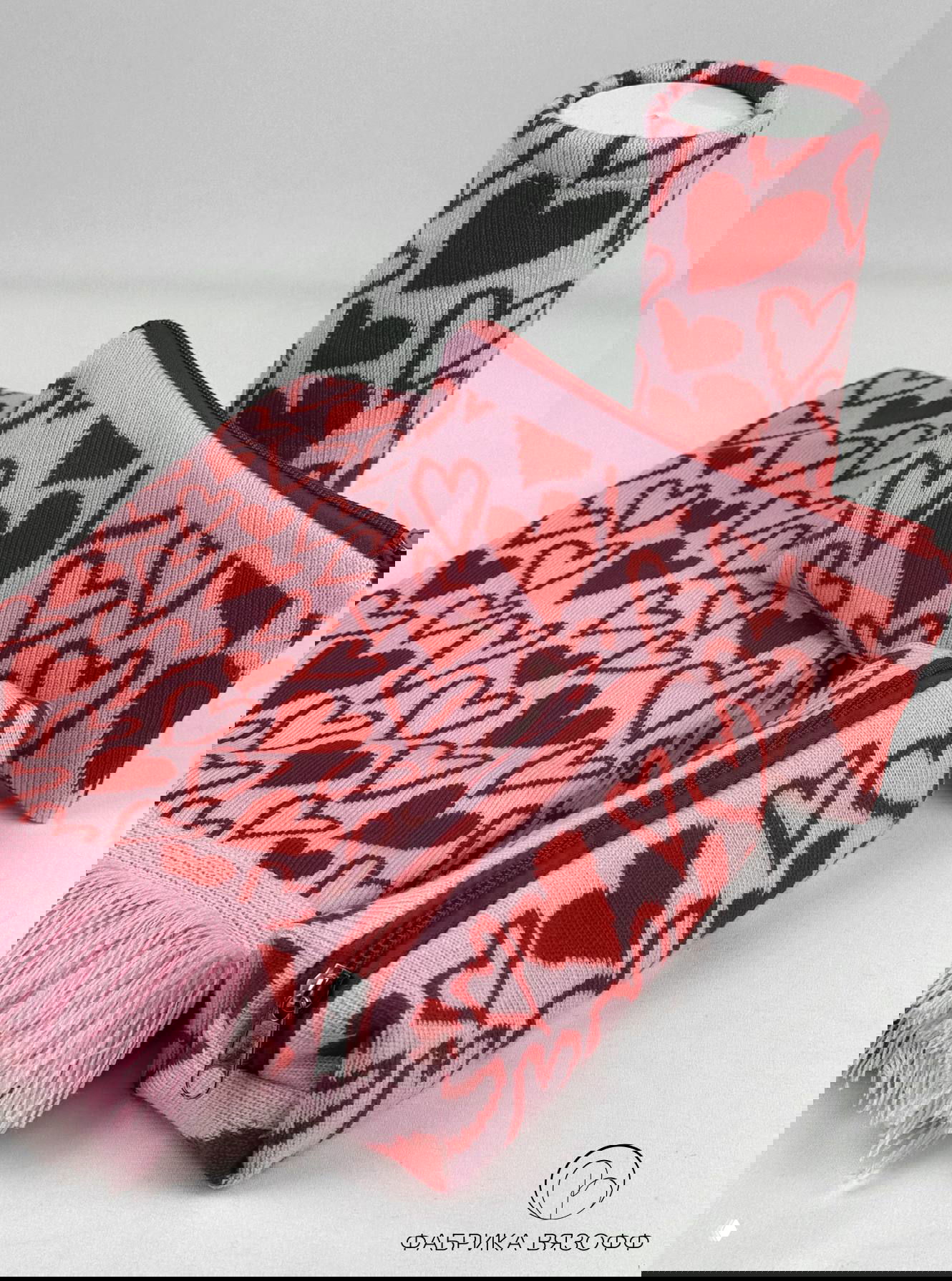 Косметичка, чехол и часть шарфа с узором сердечки на белом фоне — композиция демонстрирует формы и плотность вязки в наборе.