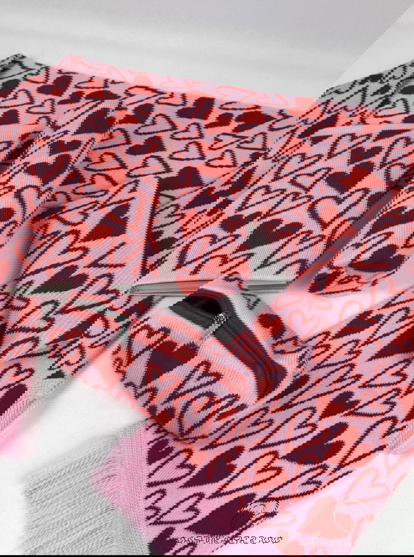 Подарочный набор: шарф, пенал и цилиндрический чехол с красными сердечками на розовом фоне, студийная съёмка для презентации подарка.