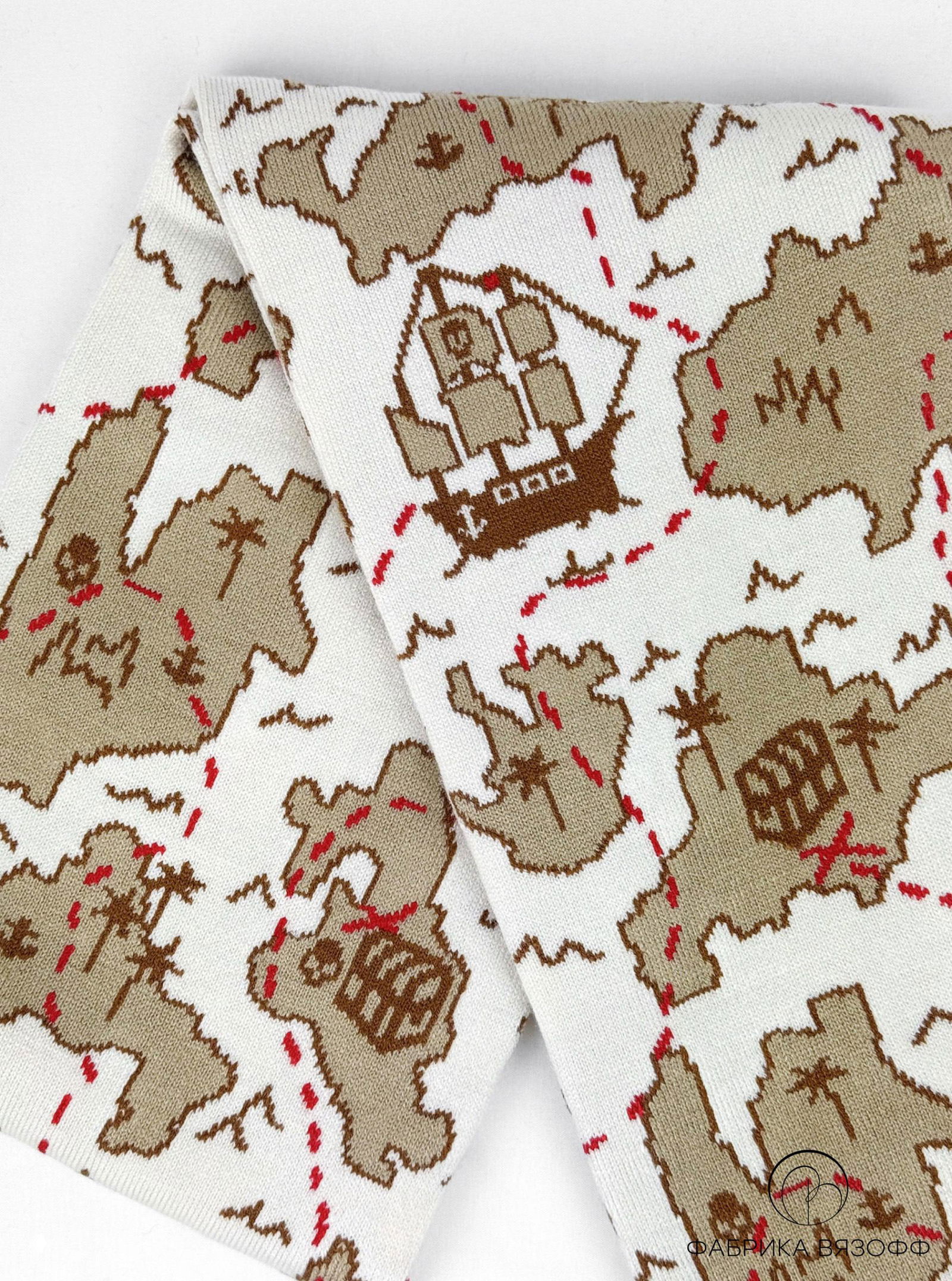 Развернутый фрагмент шарфа с рисунком корабля и островов; бежево‑коричневые мотивы на белом фоне, аккуратная отделка изделия.