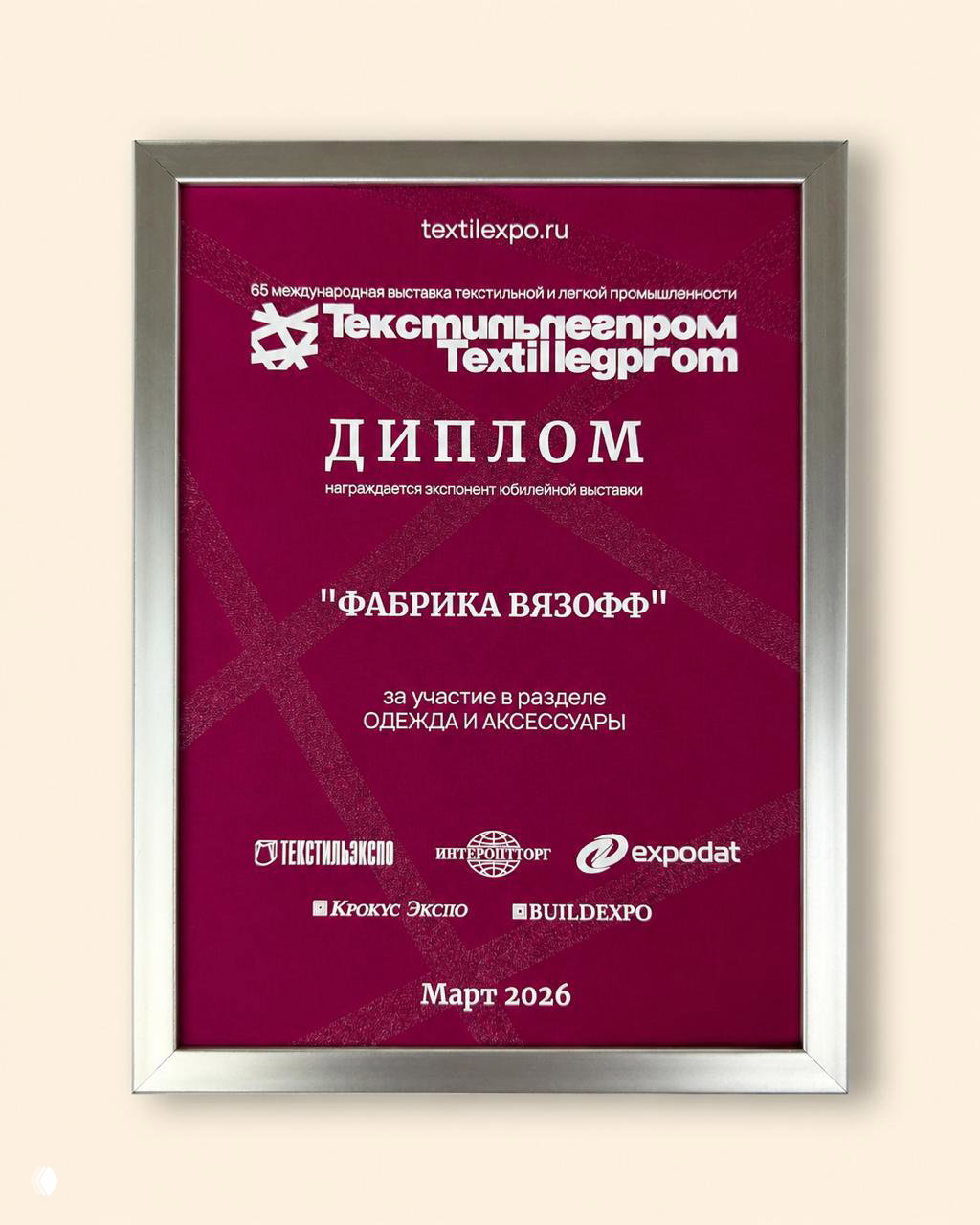 Фиолетовый диплом в серебристой раме с логотипом Textillegprom: награждение "Фабрика Вязофф" за участие в разделе Одежда и аксессуары юбилейной выставки, март 2026.