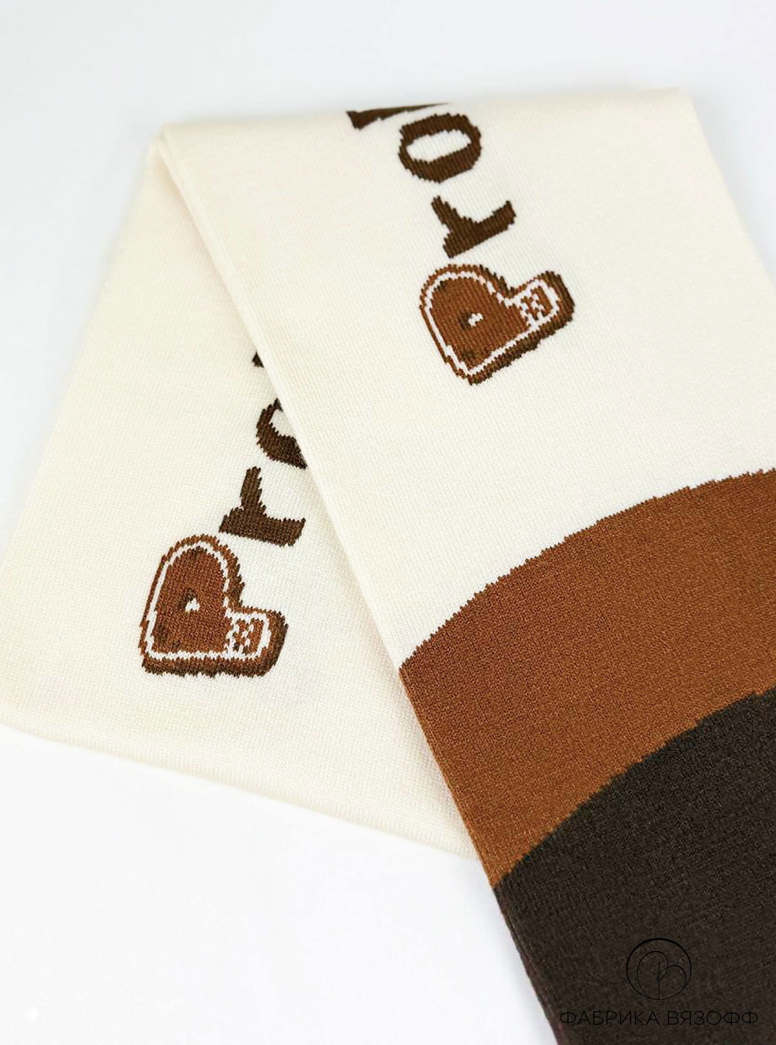 Пара сложенных друг на друга частей шарфа: контраст кремового и тёмно-коричневого полотна, чёткая жаккардовая графика и аккуратные швы.