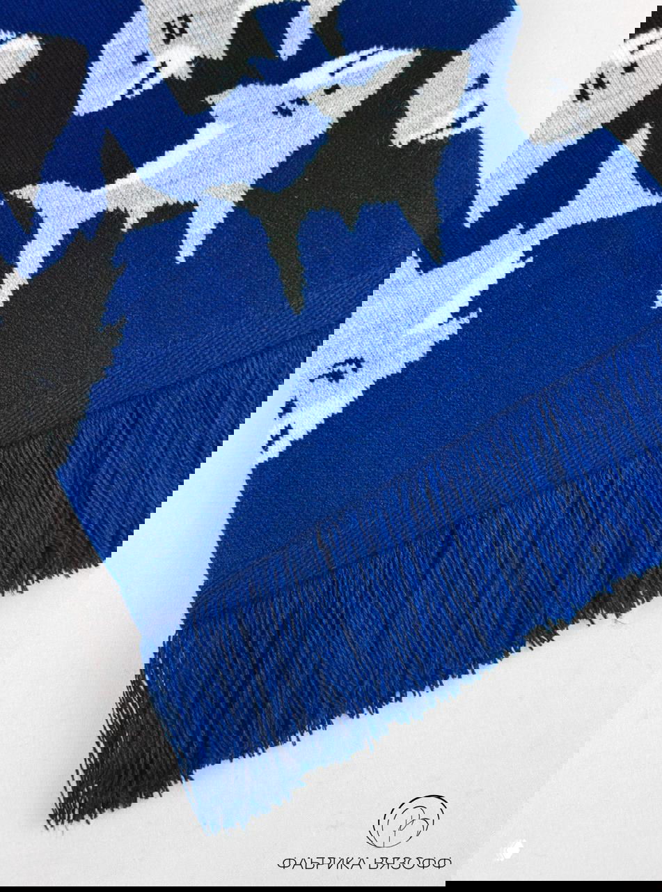 Крупный кадр синего шарфа с бахромой: видна ровная отделка края и плотная нитка, узор акул повторяется по всему полотну.