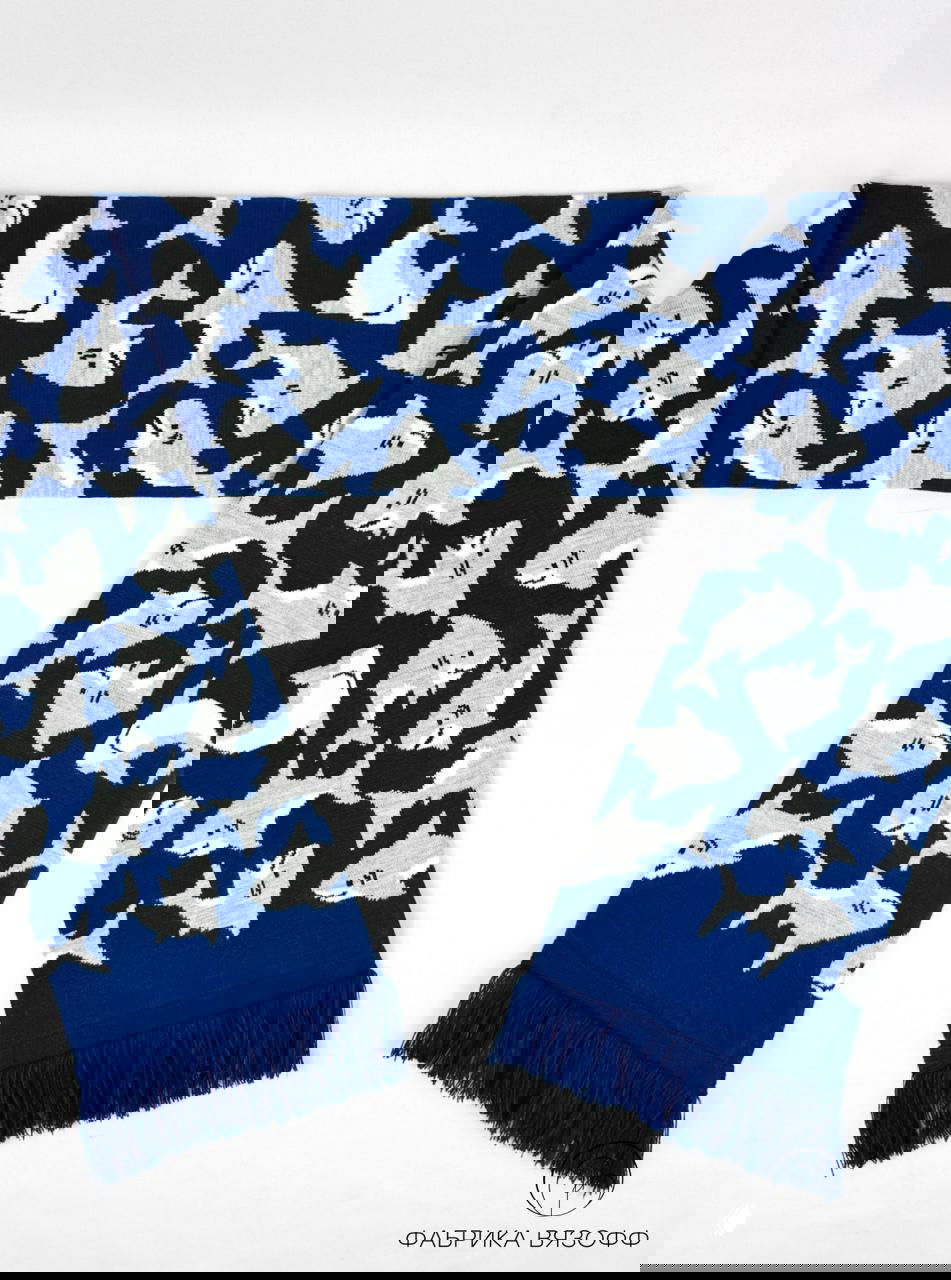 Ещё один ракурс жёлтого шарфа с лягушатами, показаны повторяющиеся мотивы и ровность вязки на светлом фоне студии.