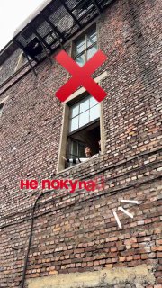 Кирпичный фасад с открытым окном, из которого выглядывает человек; на фото красный крест и текст «не покупа...», рекламное превью мерча.
