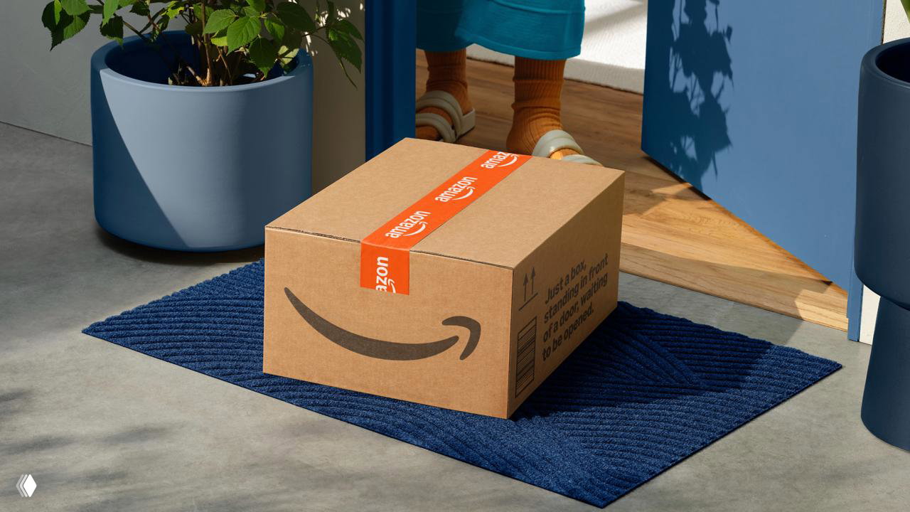 Посылка Amazon на дверном коврике у входа в дом, коробка с новой лентой и логотипом — сцена использования упаковки в реальной среде.