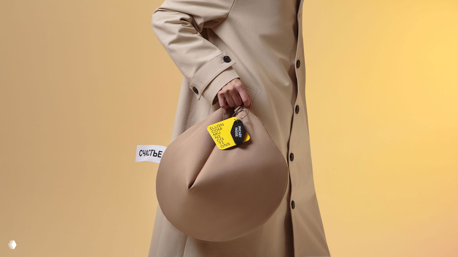 Студийный портрет модели, держащей широкий шарф с крупной надписью «СЧАСТЬЕ» на коричневом фоне — акцент на текстуре шарфа и стилистике мерча.