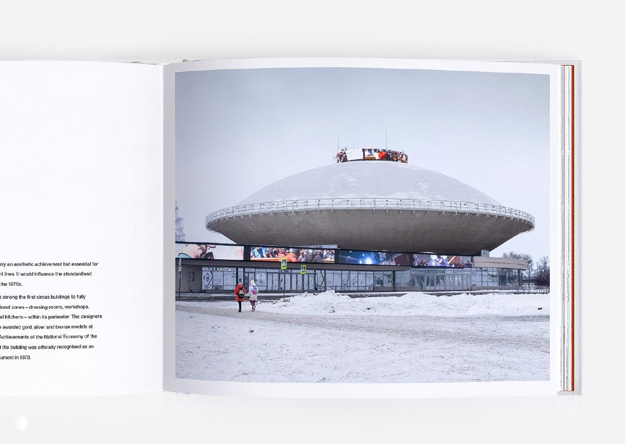 Разворот книги: фотоснимок купольного советского цирка в зимней среде, пустая площадь и пара прохожих на переднем плане