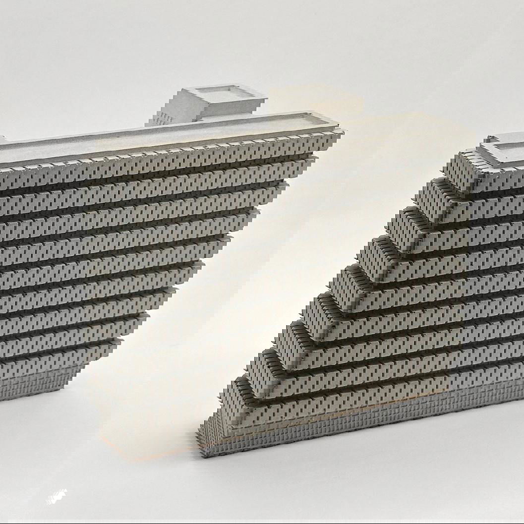 Панельная бетонная миниатюра с ритмичной сеткой окон: аккуратная геометрия и фактура, типичный сувенир в стиле советской архитектуры.