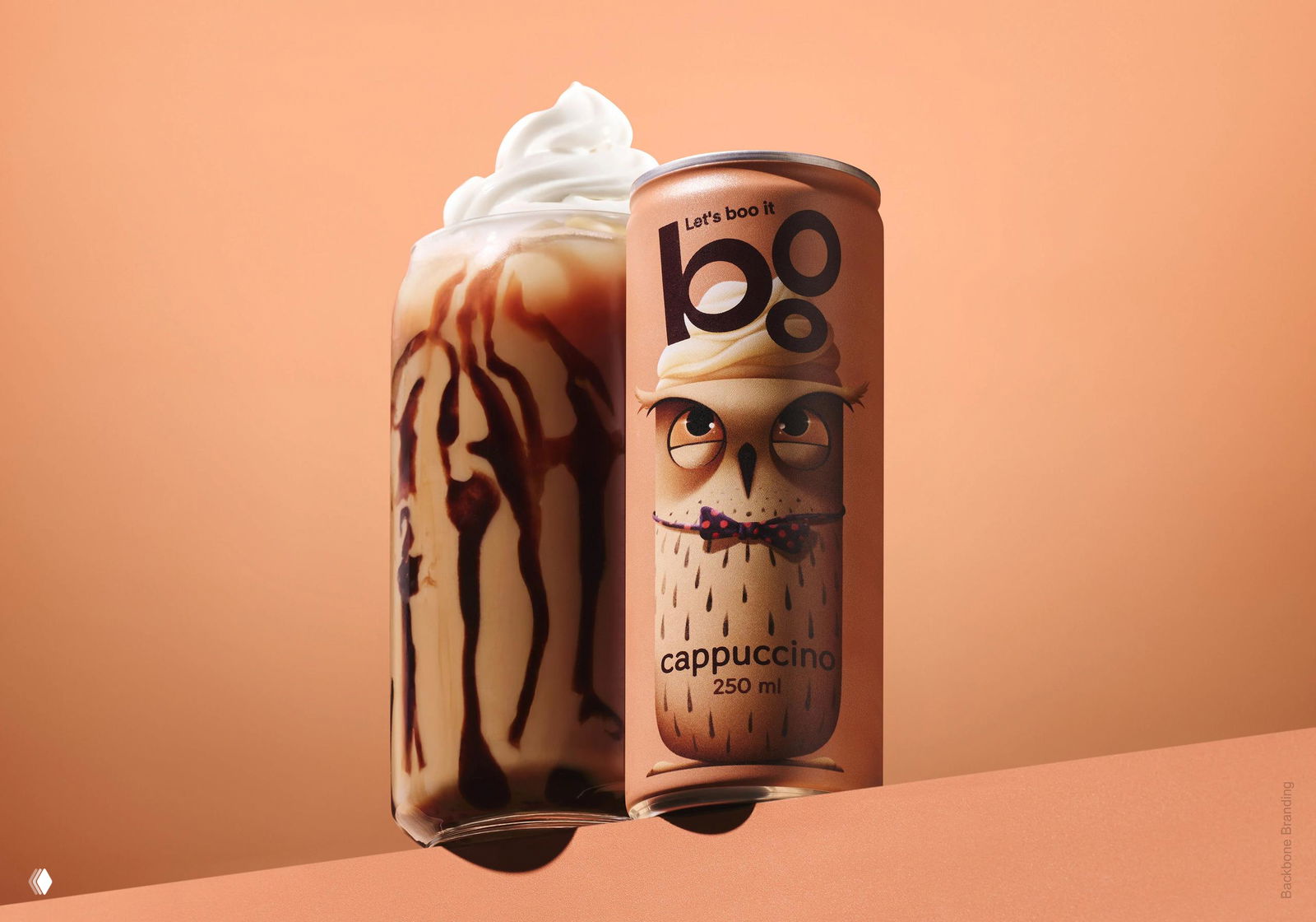 Банка Boo рядом со стаканом холодного кофе со взбитыми сливками и шоколадной подачей; акцент на продуктовой подаче и иллюстрации совы на банке.