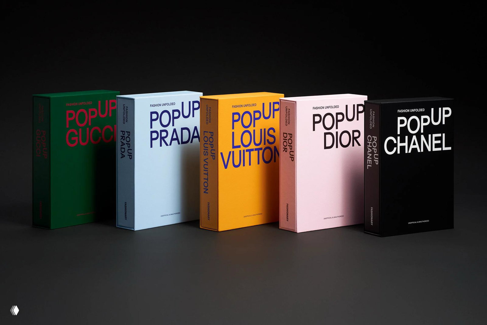Ряд коробок‑книг PopUp для известных домов моды (Gucci, Prada, Louis Vuitton, Dior, Chanel) выстроен на тёмном фоне — видна типографика обложек.