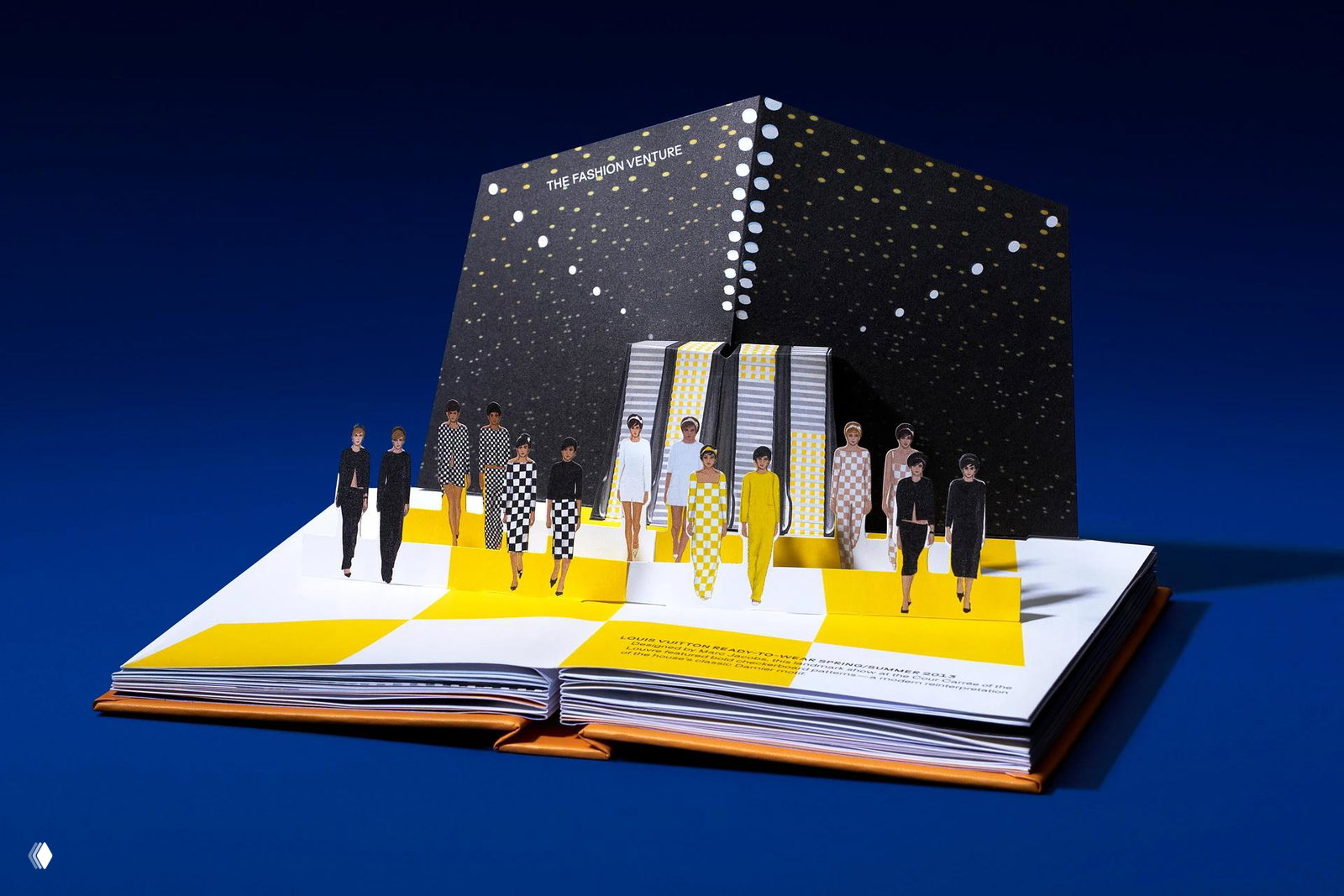Крупный план рук, держащих книгу PopUp с объёмной архитектурной моделью дома Chanel — аккуратное изготовление бумажной модели на развороте.