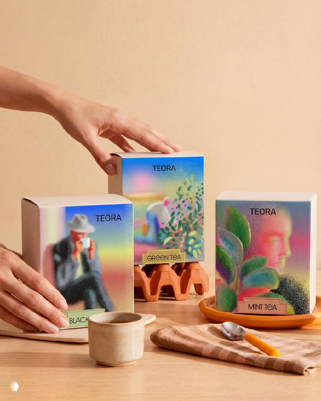 Руки взаимодействуют с коробками Teora на деревянной поверхности: демонстрация масштаба, текстуры бумаги и пастельных градиентных иллюстраций.