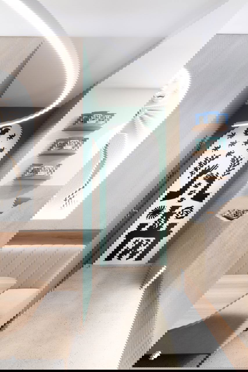 Интерьер кафе Sapiens: арочная ниша с чёрной графикой в стиле линогравюр, зелёные акценты, мягкая мебель и минималистичный дизайн.