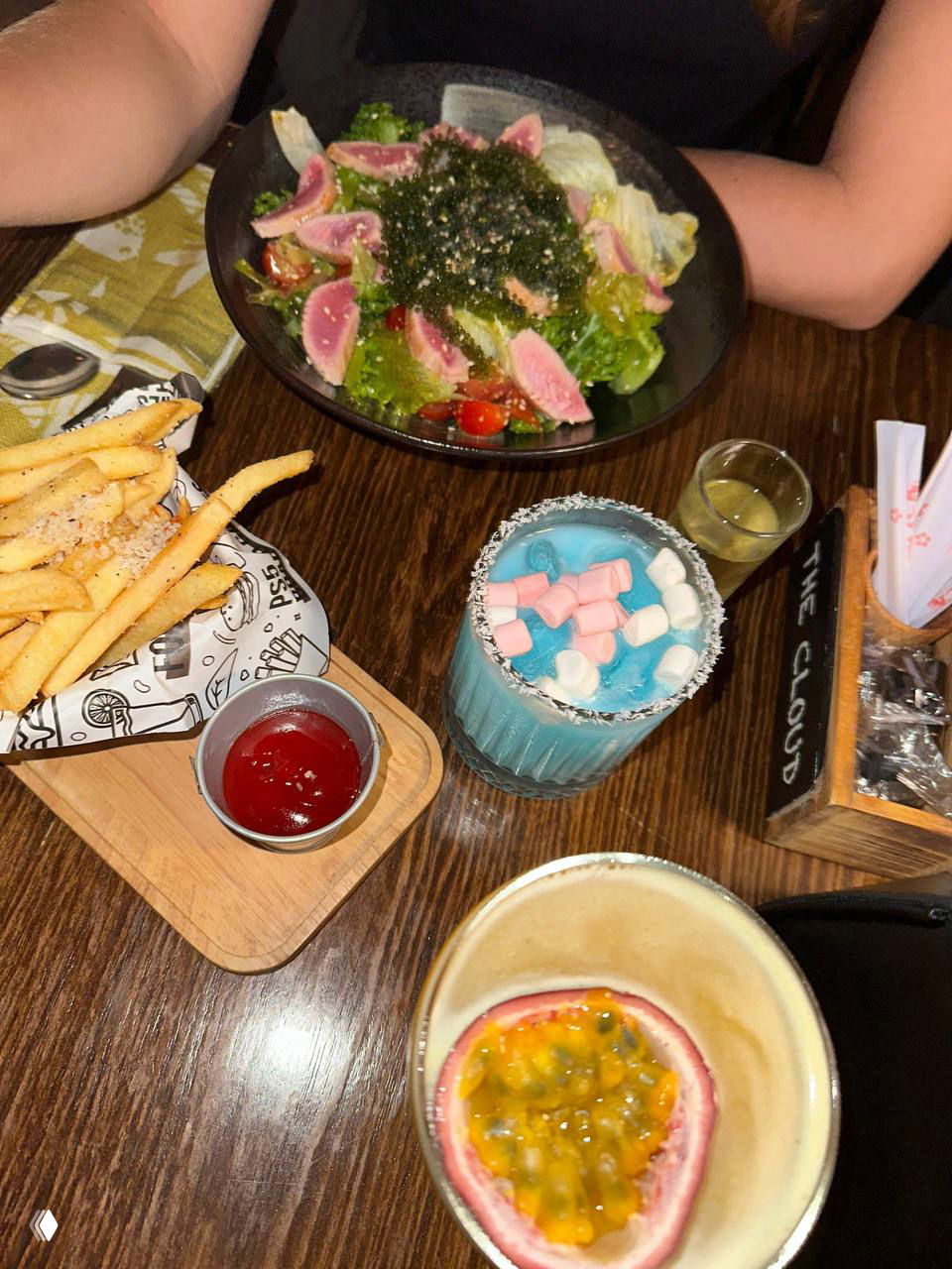 Стол с блюдами и напитками: салат с тунцом, фри, голубой коктейль с маршмеллоу и страпон с маракуйей крупным планом