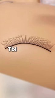 Крупный план полоски ресниц, уложенной на бежевой поверхности; видны отдельные волоски и надпись «ты», иллюстрация направления ресниц.