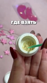 Крупный план открытой баночки с желтоватым ремувером и пластиковым шпателем в руках мастера на фоне декоративных звёздочек
