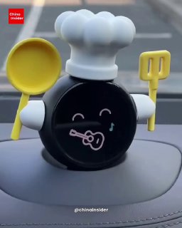 Чёрный круглый робот‑компаньон с поварской шляпой и мини‑утварью на приборной панели; творческая кастомизация персонажа владельцем.