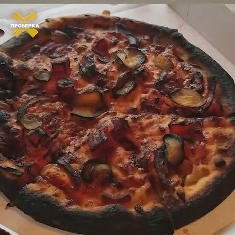 Фото пиццы с явно подпорченной поверхностью — чёрная подгорелая корочка и обугления; пример «испорченной» версии, используемой как доказательство.