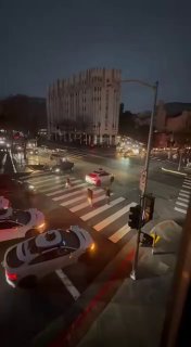 Ночной перекрёсток в Сан‑Франциско с несколькими стоящими роботакси Waymo, огнями светофоров и отражениями на мокром асфальте во время отключения света.