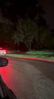 Вид с борта машины на ряд стоящих автомобилей и роботакси Waymo у темного парка в Сан‑Франциско; улица частично освещена аварийными огнями.