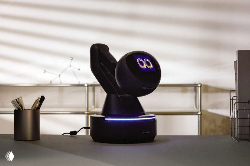 Робот Lenovo в другом положении на столе: поднятая голова с цифровыми глазами и видимым корпусом проектора, интерьер офиса позади