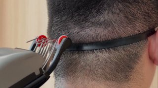Фото демонстрации умной машинки для стрижки: лезвия и направляющая насадка у затылка человека, показан процесс работы устройства рядом с маской.