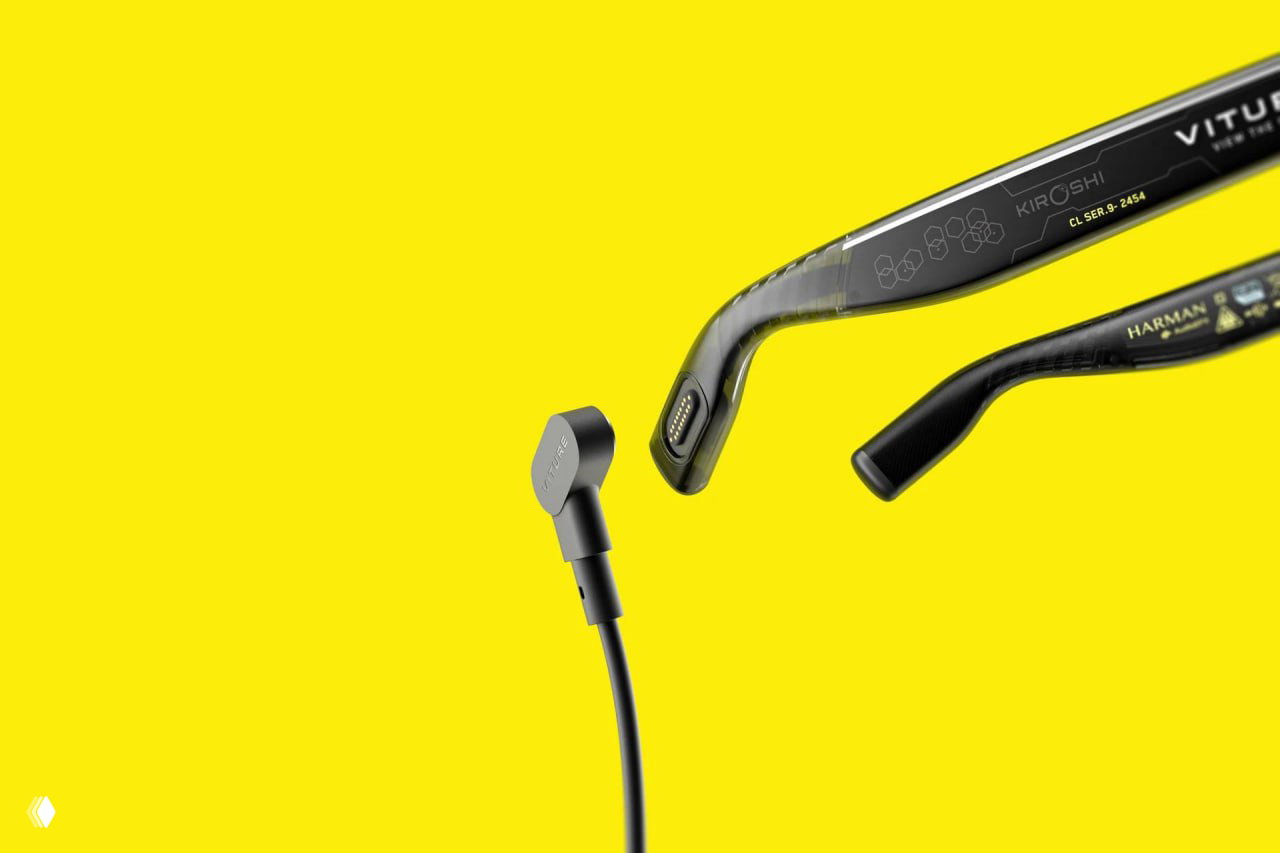 Макро-снимок дужки очков и магнитного разъёма/контакта, видны маркировки и детали крепления на жёлтом фоне, демонстрация аксессуаров