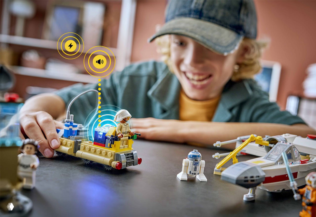 Ребёнок играет с несколькими наборами LEGO, в одном из транспортов установлен Smart Brick; показано взаимодействие и имитация звуков в игре.