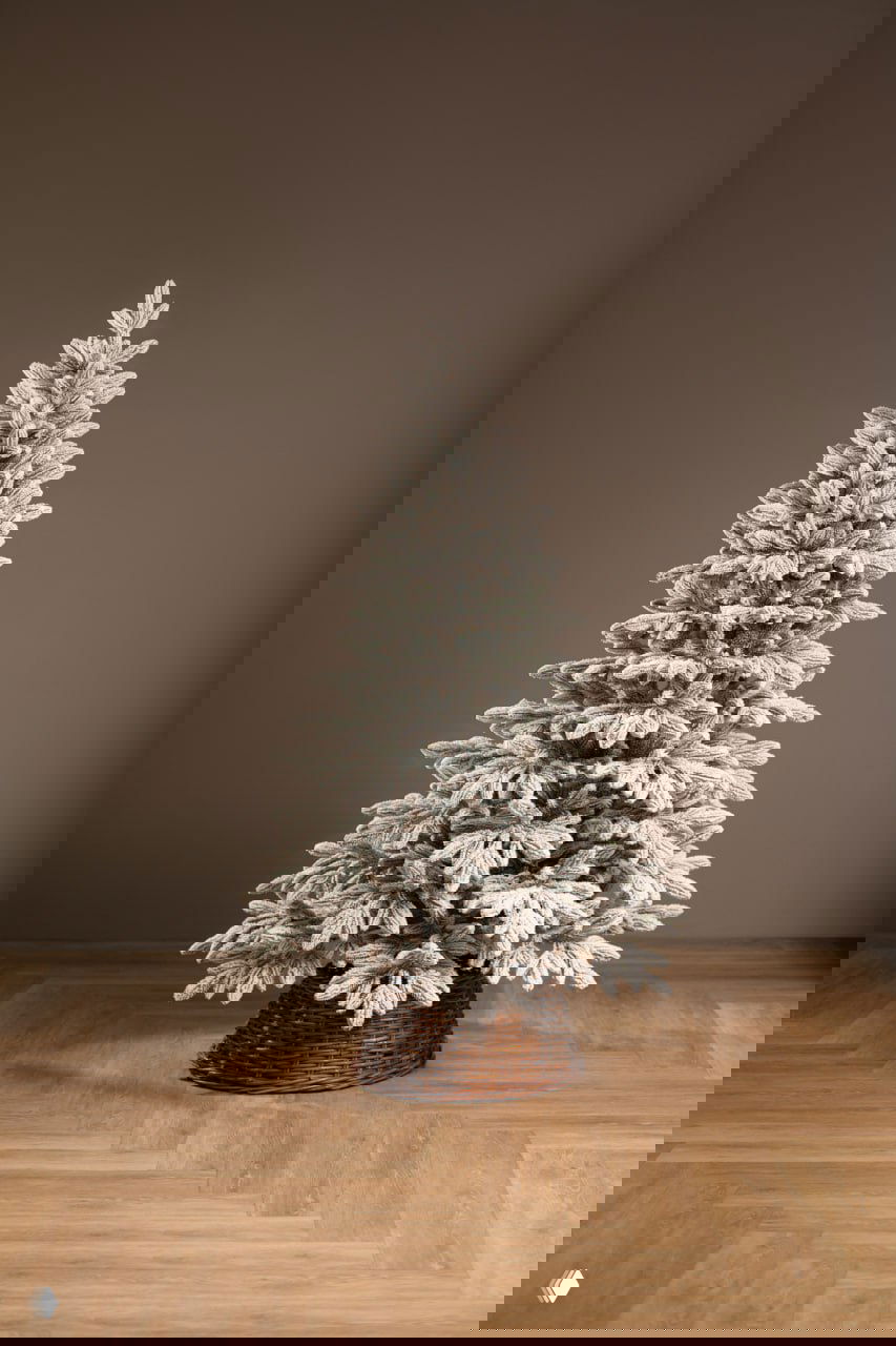 Полный вид искусственной ёлки «Донская заснеженная» высотой 180 см на плетёной подставке в сухом интерьере — имитация снега на ветвях