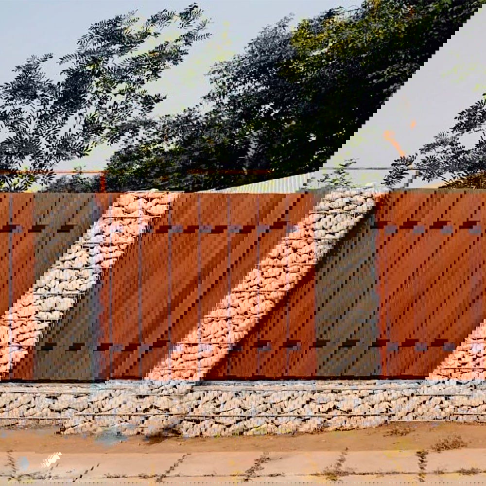 Забор из панелей ДПК: ровные деревянноподобные планки композита в сочетании со столбами из габиона, современное ограждение участка.