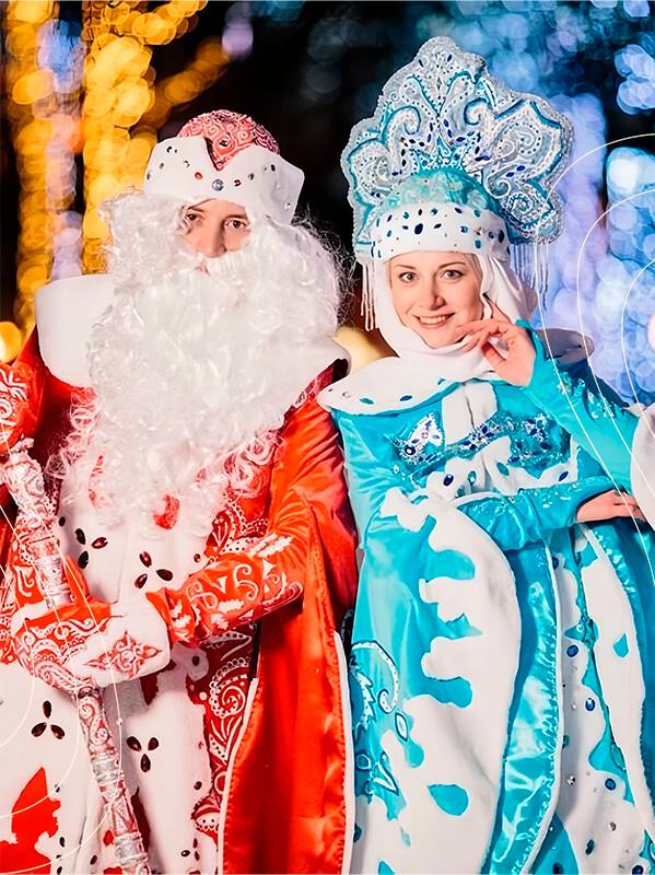 Дед Мороз и Снегурочка в праздничных костюмах на площадке в Твери: яркие огни, народ и праздничная атмосфера города.