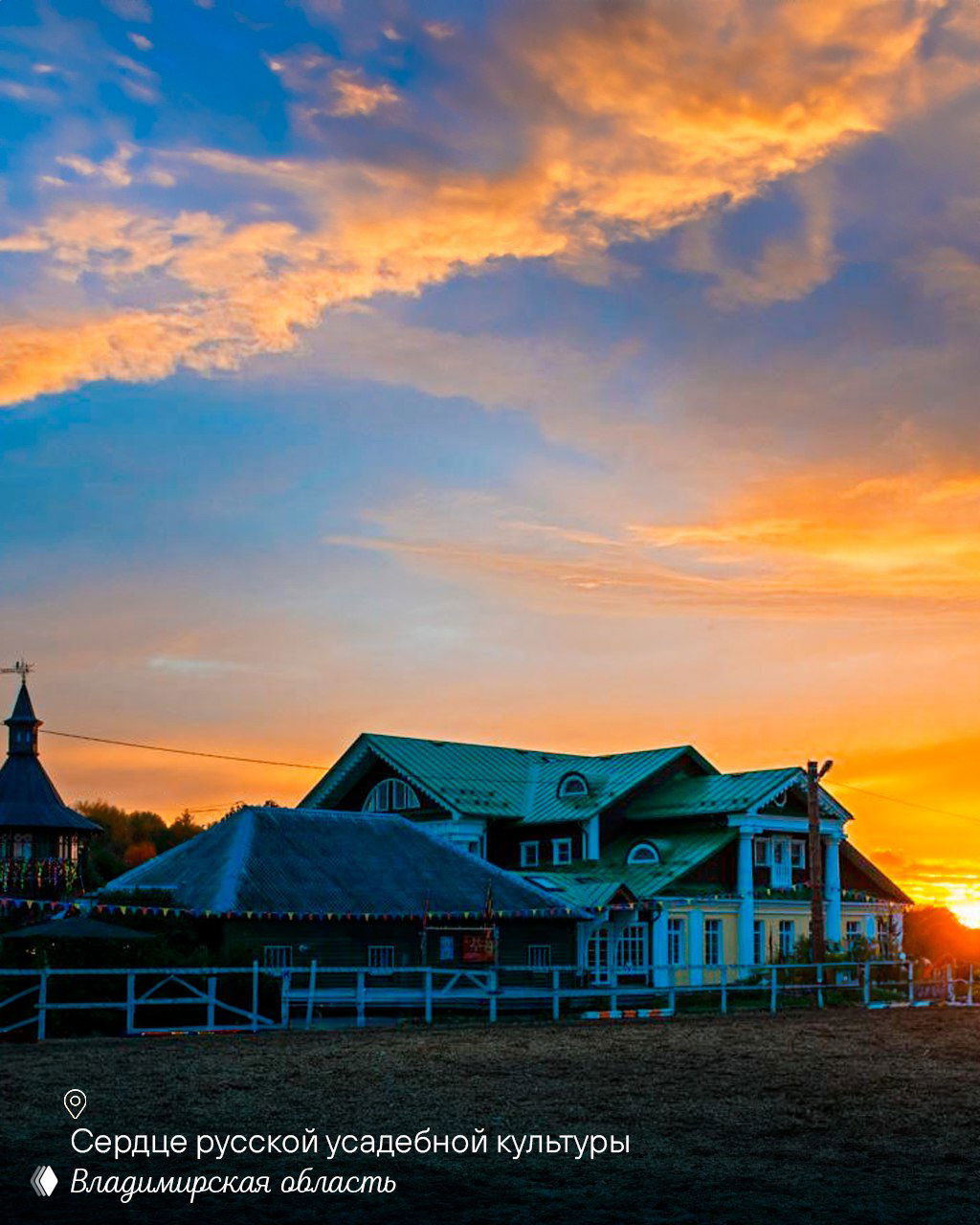 Русская усадьба на ровной площадке на фоне пылающего заката; деревянные постройки и простор для прогулок и сельских мероприятий.