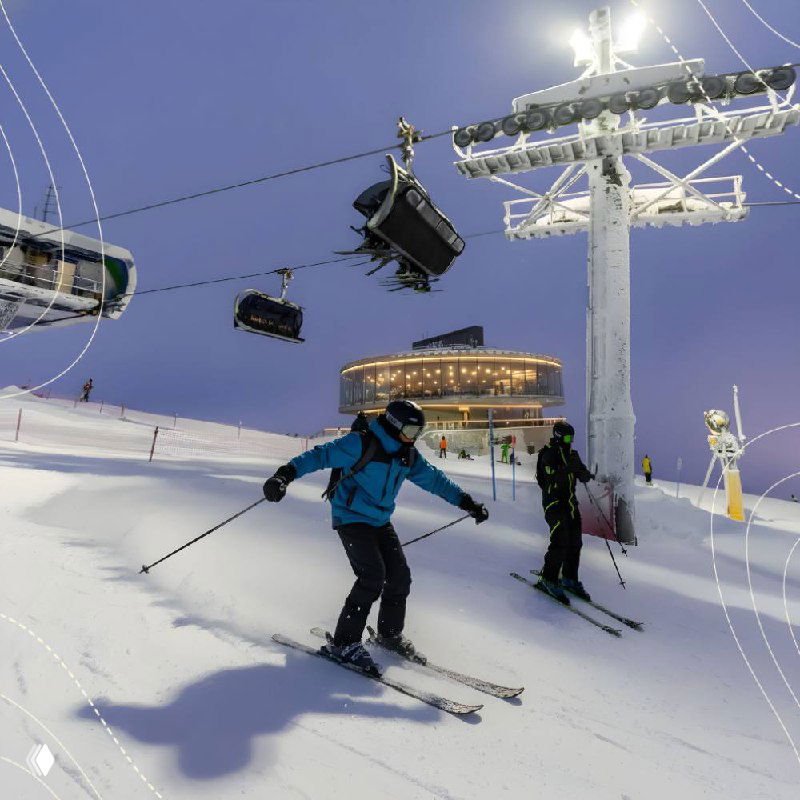 Горнолыжный курорт: подъёмник и лыжник на снежном склоне, ночное или вечернее освещение инфраструктуры курорта и трасс.
