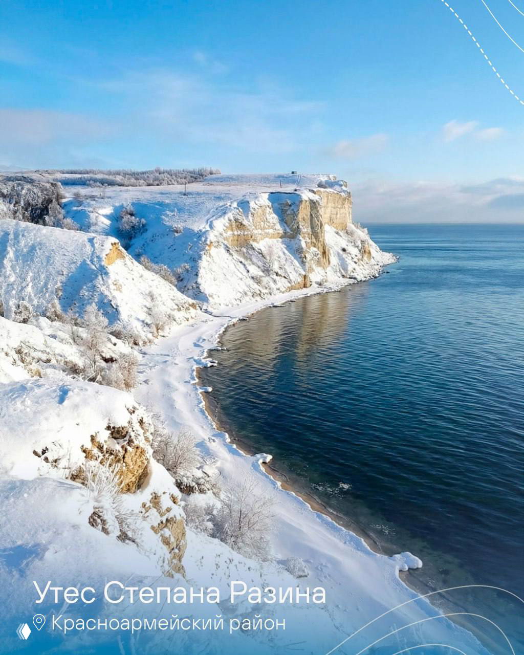 Утёс Степана Разина у реки: заснеженные меловые скалы, широкая водная поверхность и чистое зимнее небо над берегом.