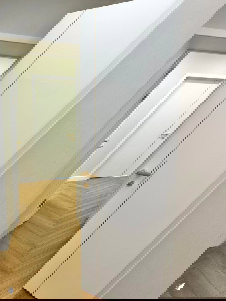 Открытая дверь Лайн 12 демонстрирует соотношение молдинга и полотна, интерьерный паркет и аккуратные белые наличники в минималистском интерьере.