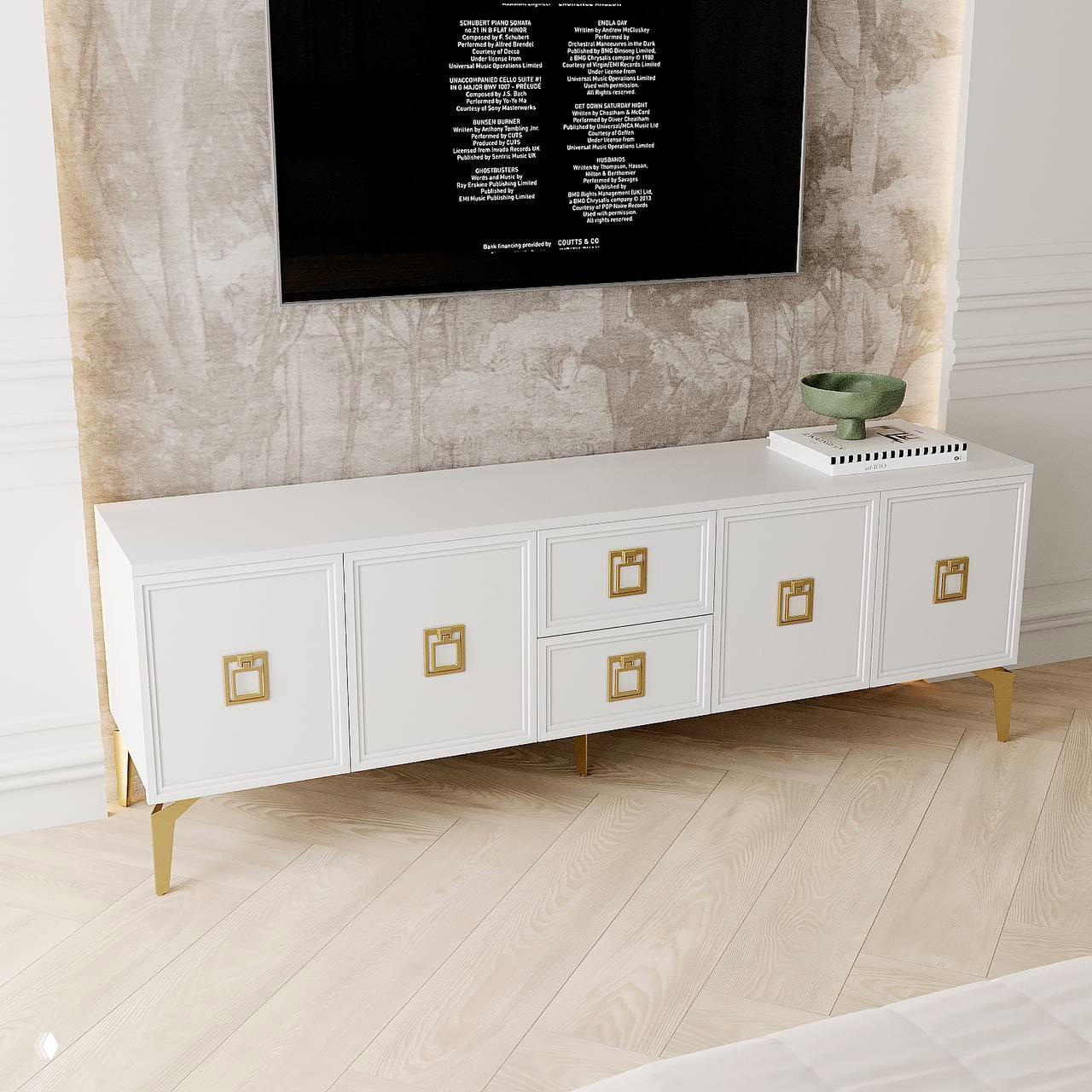 Низкая ТВ-тумба белого цвета из серии СИРИУМ с декоративными золотыми ручками, установленная под настенным экраном на нейтральном фоне.