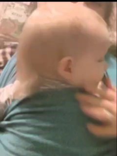 Младенец в слінге, его держит взрослый — ракурс со спины, изображение иллюстрирует близость и совместный быт матери и ребёнка.