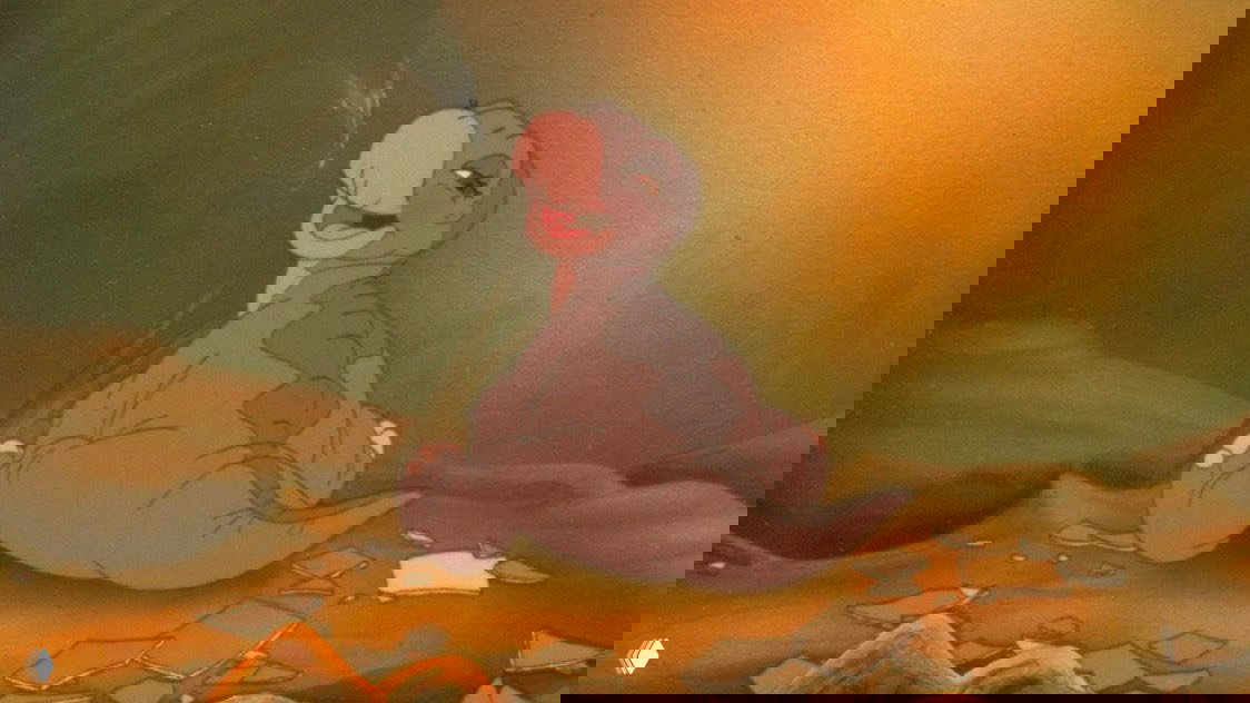 Портретный кадр молодого динозавра на фоне земли и обломков: выражение дружелюбное, цветовая палитра вызывает ностальгию по классической анимации.