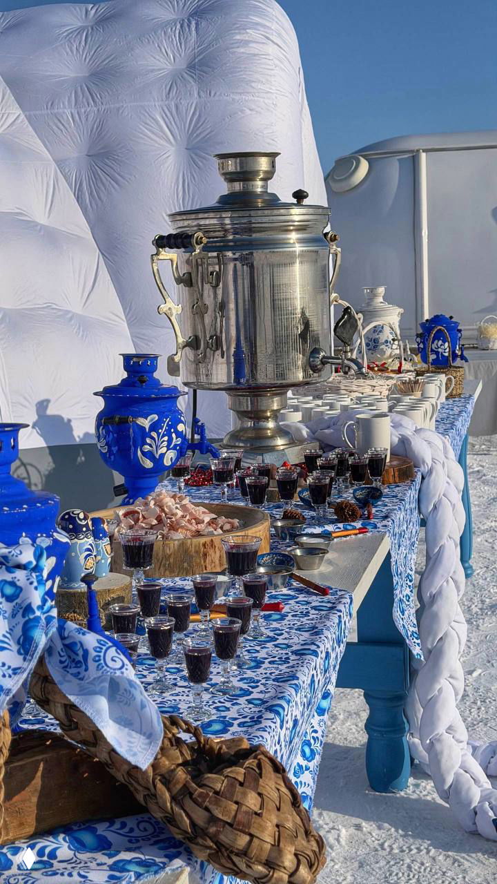 Сервировка с самоваром и русскими чайными чашками на столе на льду: традиционный стол с угощениями во время мероприятия на Байкале.