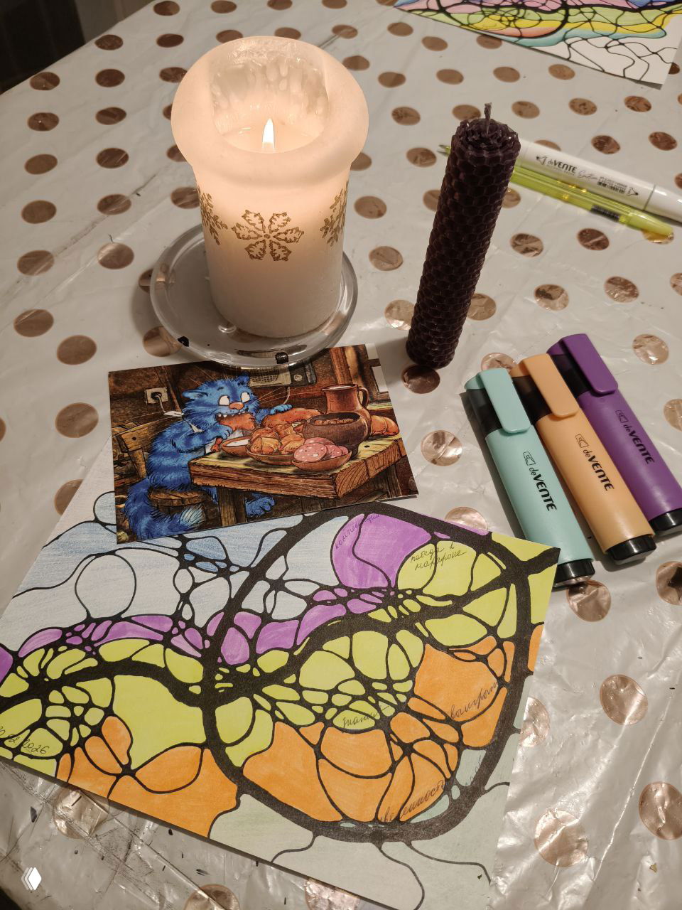 Крупный план рабочего стола: зажжённая свеча, толстая пчелиная свеча, маркеры и цветной нейрографический рисунок в фокусе — материалы процесса.